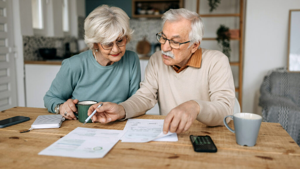 Older couple taxes paperwork table getty
